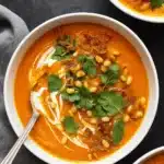Carrot ginger soup with coconut cream and toppings