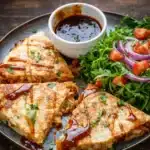 BBQ Chicken Quesadillas cut into wedges with cheese and BBQ sauce