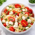 A vibrant bowl of Easy Caprese Pasta Salad with balsamic glaze