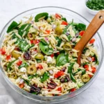 A colorful Mediterranean Orzo Salad in a white bowl with feta and olives.