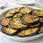 Golden-brown Crispy Oven-Baked Eggplant slices on a wooden board