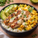A vibrant Easy Street Corn Chicken Rice Bowl topped with cilantro and lime.