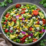 Vibrant Mexican Chopped Salad in a wooden bowl with lime and avocado.